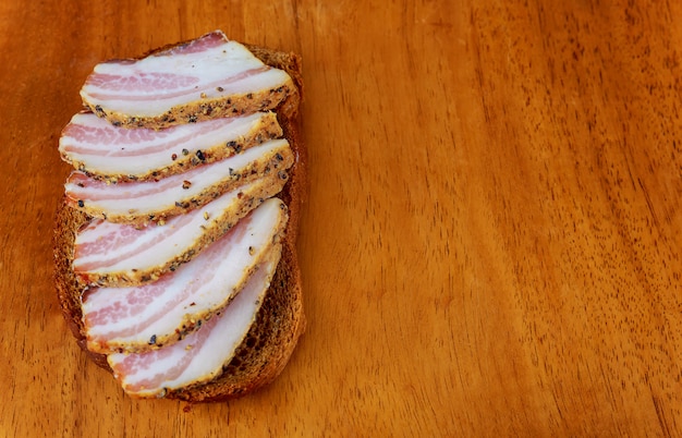 Comida ucraniana Fatias apetitosas de salo mentem sobre uma mesa de cozinha escura