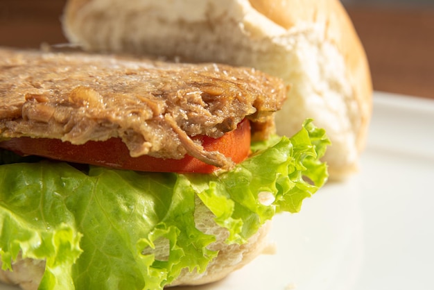Comida vegan Hambúrguer vegano e molhos em um prato branco sobre foco seletivo de madeira