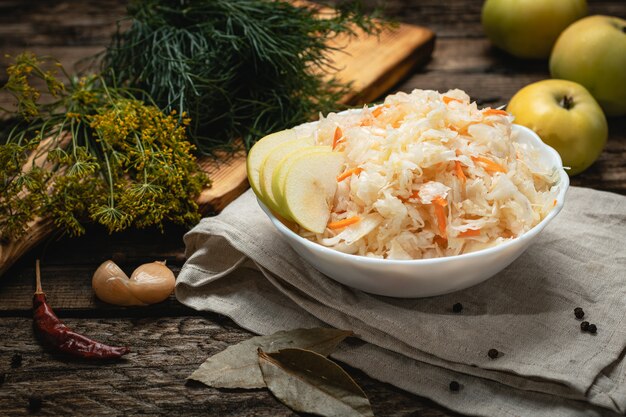 Comida vegana - chucrute com maçãs em uma superfície de madeira