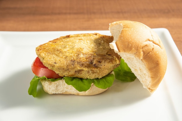 Comida vegana Hamburguesa vegana y salsas en un plato blanco sobre enfoque selectivo de madera