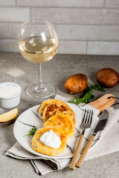 Comida vegana. panquecas de batata com purê de queijo, costeletas com endro e creme de leite. em pedra cinza, copyspace