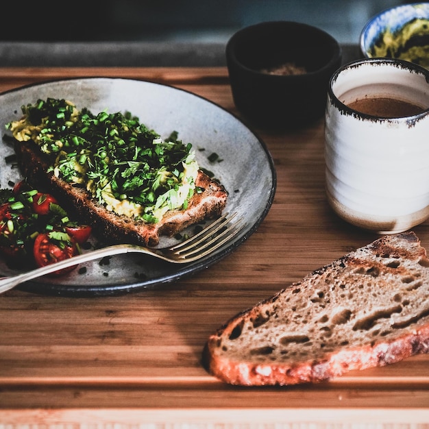 Comida vegana con tostadas de aguacate y cultivo cuadrado de café