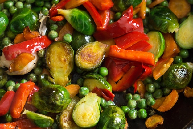 Comida vegetariana a base de verduras fritas, coles de Bruselas y zanahorias.