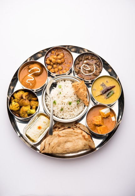 La comida vegetariana india Thali o plato incluye mantequilla paneer masala, dal makhani o tarka, chole papad, kofta curry, gulab jamun, aloo-gobi sabji, chapati y arroz con dulce bengalí servido