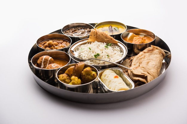 La comida vegetariana india Thali o plato incluye mantequilla paneer masala, dal makhani o tarka, chole papad, kofta curry, gulab jamun, aloo-gobi sabji, chapati y arroz con dulce bengalí servido