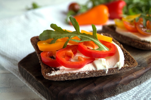 Comida vegetariana. Pan de centeno con queso blando y verduras.