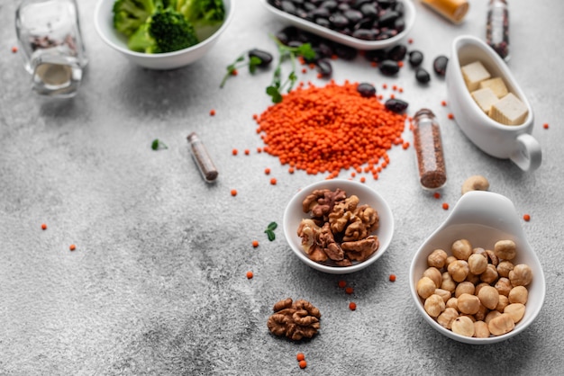 Comida vegetariana saudável em um fundo de concreto com espaço de cópia. nozes, feijões, verduras e sementes