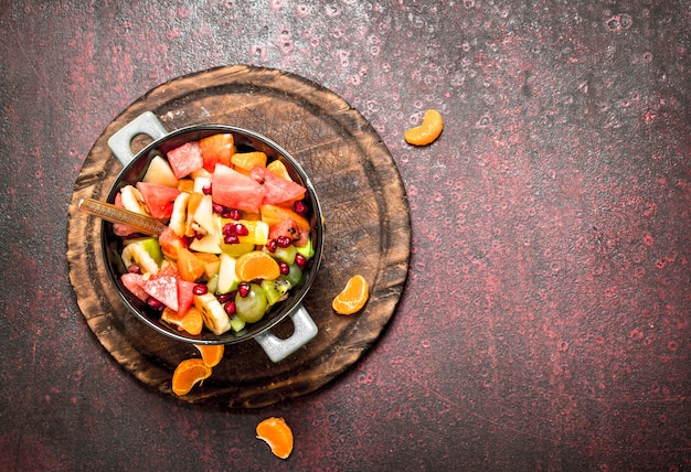 Comida de verano Ensalada tropical de frutas exóticas sobre fondo rústico