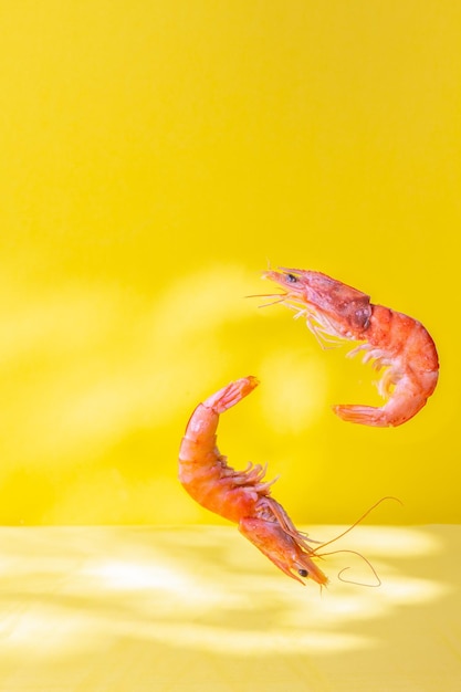 Comida voadora Camarões de frutos do mar com fundo amarelo limão e coentro