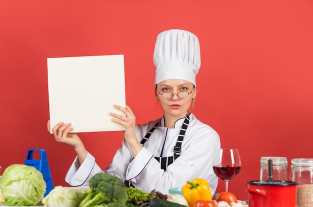 Comience a contar las calorías Trabaja en una cocina moderna La chef mujer lee un libro de cocina Se puede usar para cocinar Estudio de comida en el restaurante Chef preparando receta Libro de recetas El mejor concepto de cocina de recetas