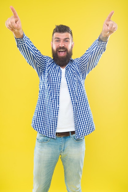 Comienza la celebración. Moda de barba y concepto de barbero. Hombre barbudo hipster elegante barba fondo amarillo. Cuidado de barba y bigote. Apariencia hipster. Expresión emocional. Las puntas de barbero mantienen la barba.