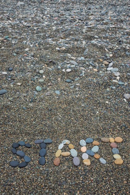 Comienzo hecho de piedras en la playa arenosa