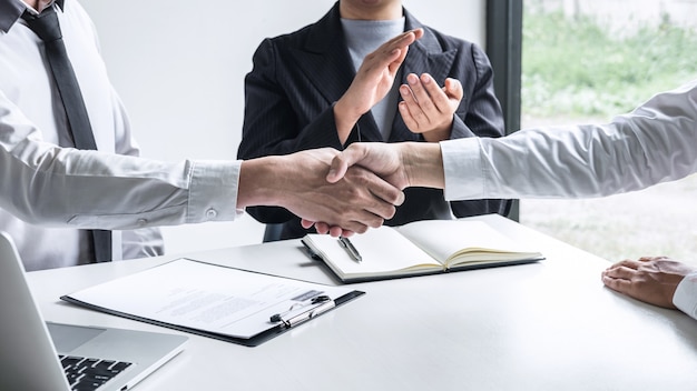 Foto el comité y los nuevos empleados se dan la mano después de un buen trato