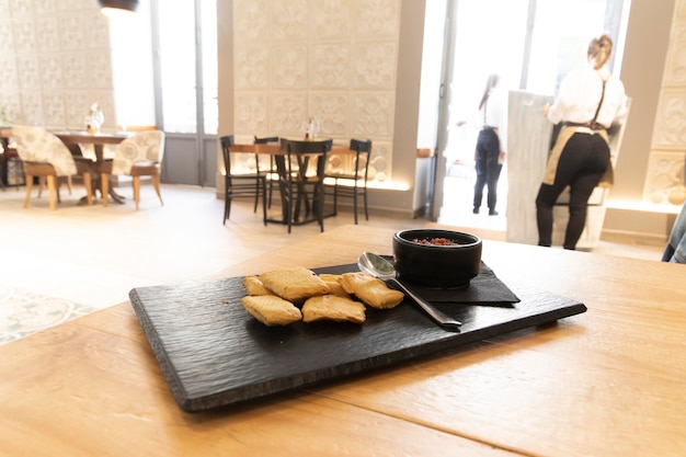 Como aperitivo, un bol de salsa de tomate italiana, sobre una mesa de madera en el interior de un luminoso restaurante.