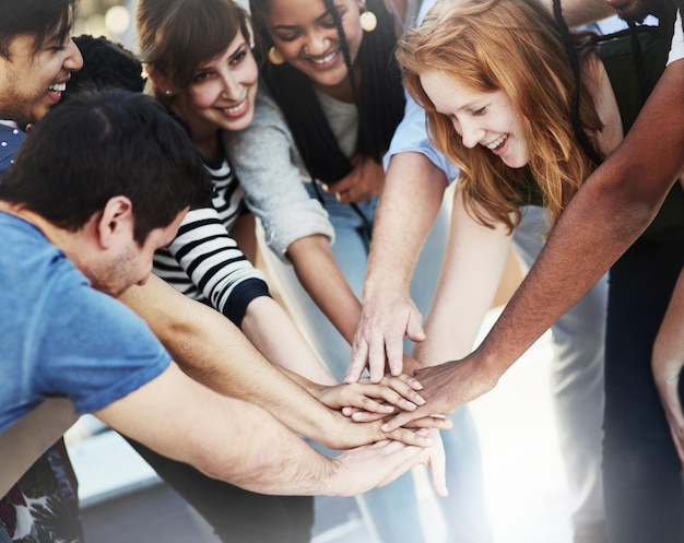 Como equipo Captura recortada de empresarios irreconocibles que se unen como equipo