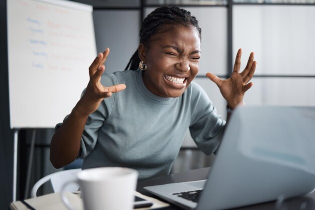 Como essa coisa ousa bater em mim Foto de uma jovem empresária com raiva enquanto usa um laptop em um escritório