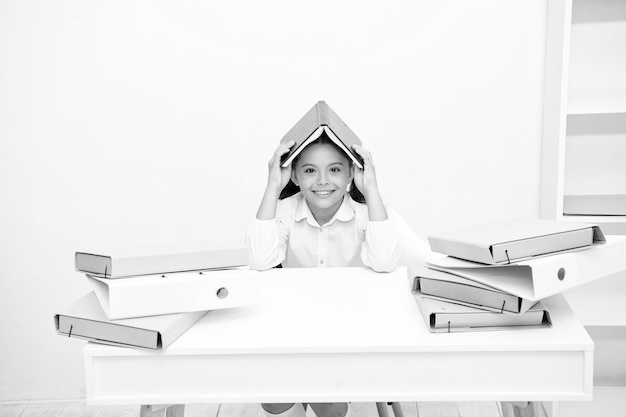 Cómo mantener una actitud positiva y administrar las tareas Niña niño libro techo cabeza fondo blanco Colegiala mantenerse positivo sonriendo leyendo estudiando Niño uniforme escolar cara sonriente Colegiala escondiéndose de la realidad
