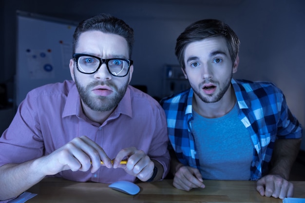 Como pode ser. Agradável surpreendeu homens simpáticos sentados juntos e olhando para a tela do computador enquanto demonstravam seu espanto