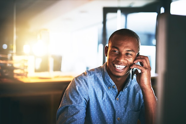 Cómo va el trabajo Gran toma de un joven hombre de negocios usando un teléfono móvil durante una noche en una oficina moderna