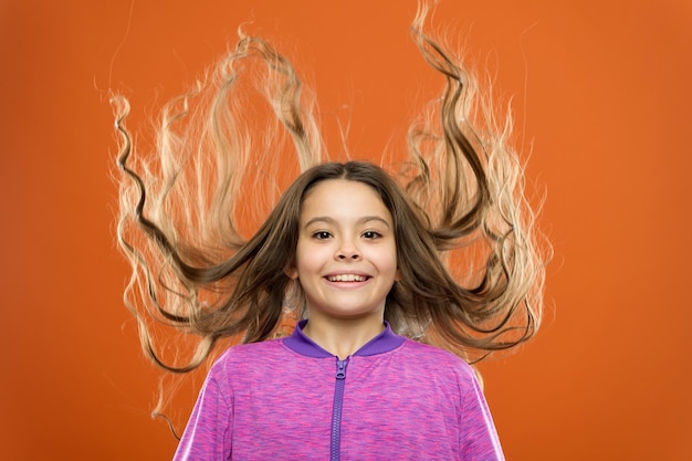 Como tratar o cabelo encaracolado Penteado bonito e arrumado Dicas fáceis para fazer penteado para crianças Cabelo comprido de criança pequena Beleza encantadora Garota criança ativa com cabelos longos lindos Conceito de cabelo forte e saudável