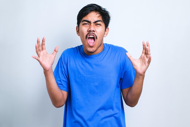 Como você pode? Retrato de homem asiático frustrado e irritado, de pé com as mãos levantadas, perguntando por quê. estúdio interno filmado sobre fundo branco