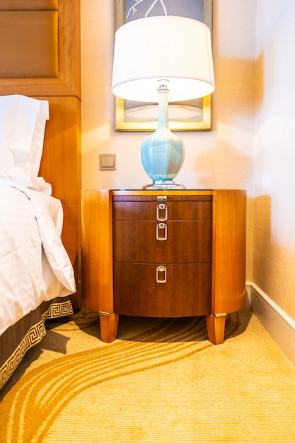 Cómoda almohada blanca en la cama con decoración de lámpara de mesa en el dormitorio del hotel