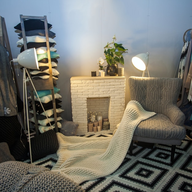 Foto cómoda casa en el interior en color gris con chimenea y lámpara blancas