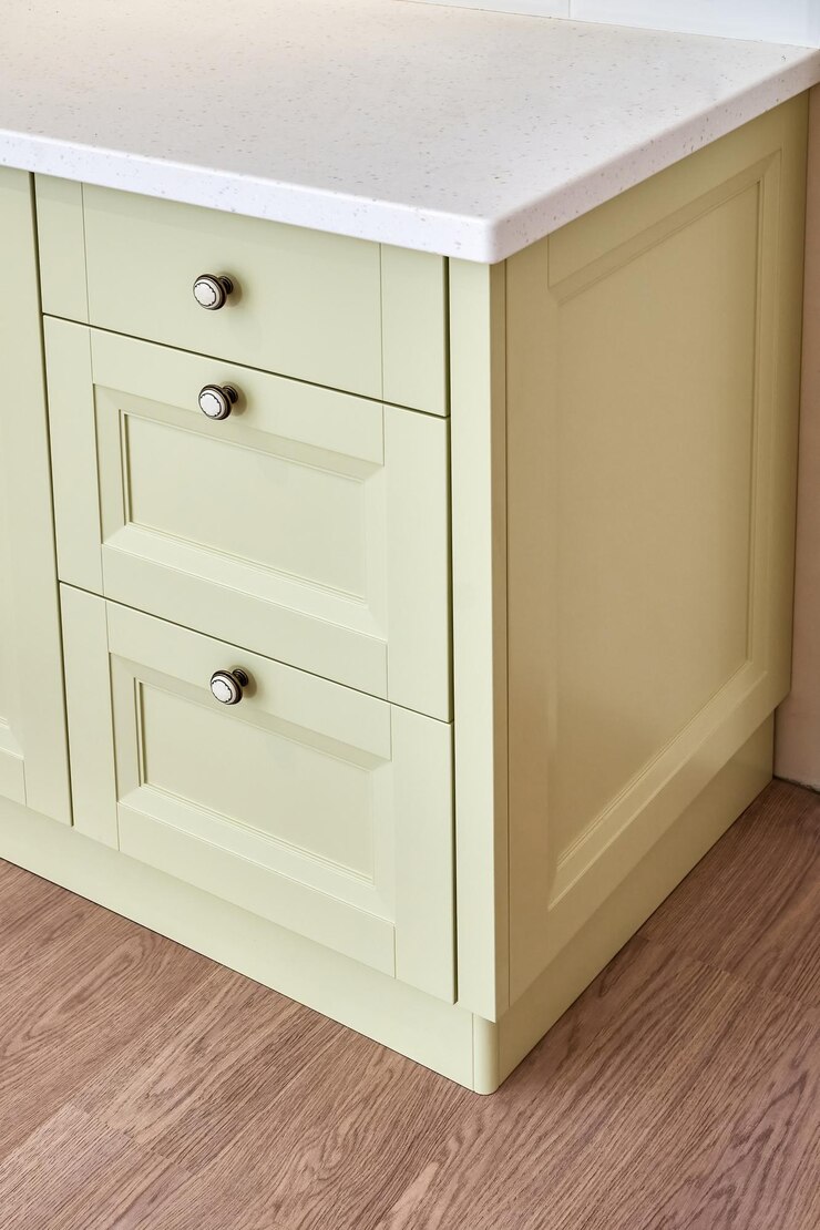 Cómoda clásica con fachadas de color verde claro y encimera de superficie sólida acrílica