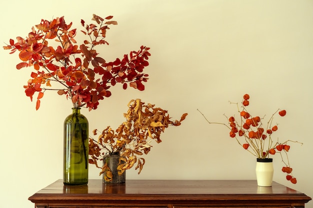 Cômoda de madeira com galhos florais em vaso