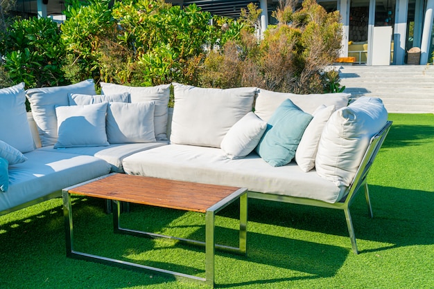 cómodas almohadas en una silla y mesa de patio al aire libre