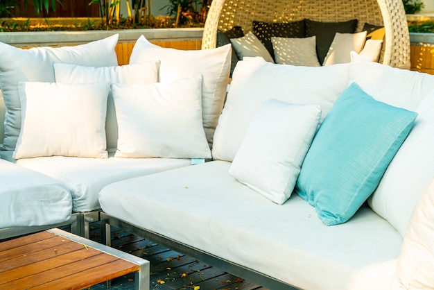 cómodas almohadas en una silla y mesa de patio al aire libre