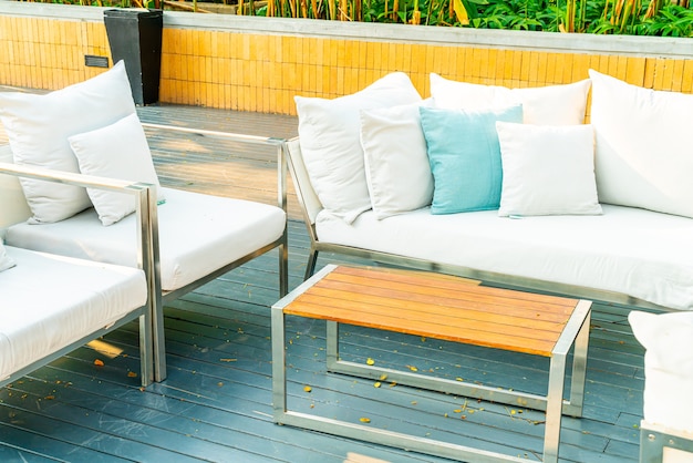 cómodas almohadas en una silla y mesa de patio al aire libre