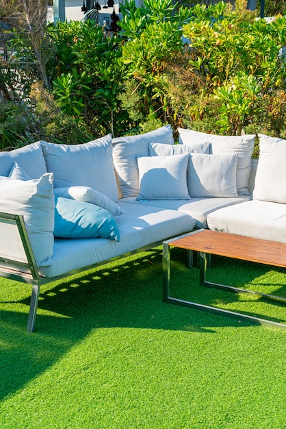 cómodas almohadas en una silla y mesa de patio al aire libre