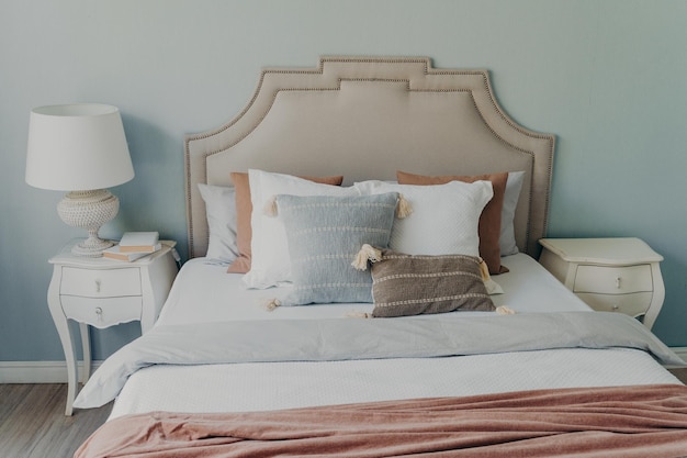 Cómodo interior de dormitorio y almohadas suaves textiles en la cama Concepto de descanso en casa en una habitación acogedora