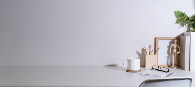 Cómodo lugar de trabajo con papelería de café y planta de interior en mesa blanca