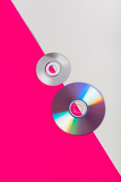 Compact Discs auf einem rosa und weißen Dual-Hintergrund