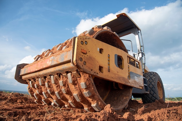 Compactador de suelo vibratorio amarillo que trabaja en el sitio de construcción de carreteras