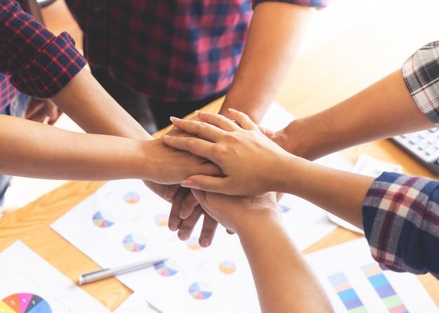 Compañero de trabajo de amigos de personas compañero de equipo colocando la mano juntos para el concepto de equipo