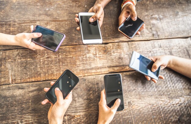 Compañero de trabajo con teléfono móvil inteligente sobre fondo de madera