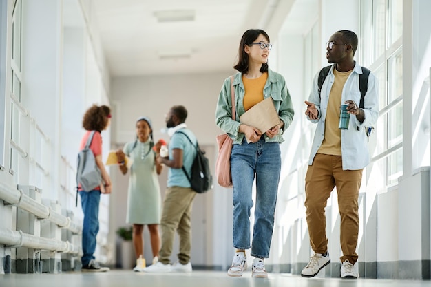 Compañeros de clase caminando por el pasillo de la escuela