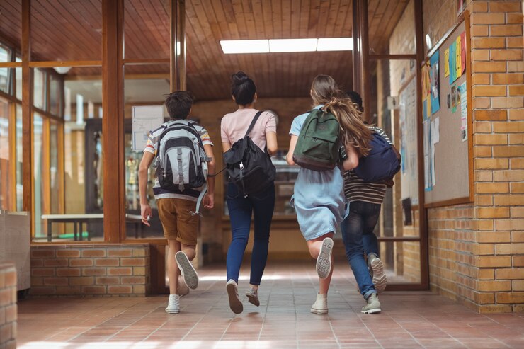 Foto compañeros de clase emocionados corriendo en el pasillo