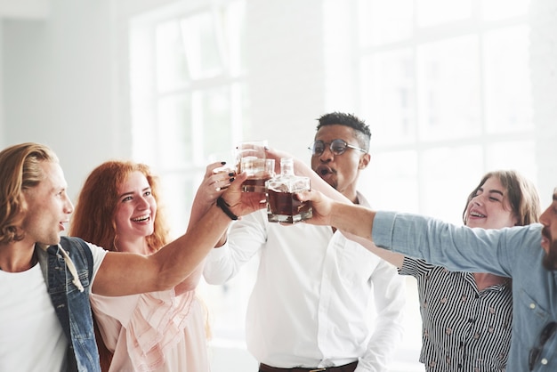 Foto compañeros de equipo bebiendo whisky y riendo por un trato exitoso