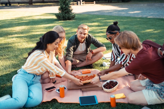 Compañeros felices preparándose para comer en el hilo de la universidad