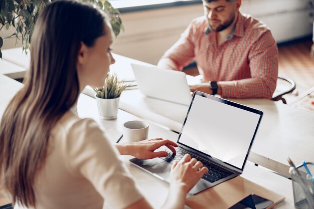 Compañeros masculinos y femeninos que trabajan en la mesa en la oficina