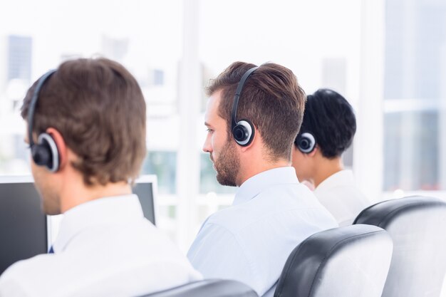 Compañeros de trabajo con auriculares en una fila