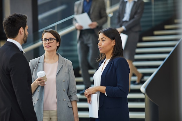 Compañeros de trabajo discutiendo el plan del proyecto en el lobby