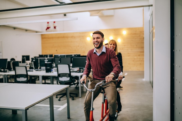 Compañeros de trabajo divirtiéndose montando en bicicleta