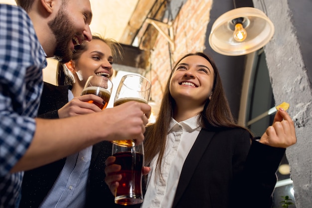 Compañeros de trabajo felices celebrando el evento corporativo después de un día de trabajo tenso. Mira encantado