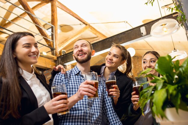 Compañeros de trabajo felices celebrando el evento corporativo después de un día de trabajo tenso. Mira encantado