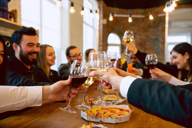 Compañeros de trabajo felices celebrando mientras la fiesta de la empresa y el evento corporativo. Jóvenes caucásicos en traje de negocios animando, riendo. Concepto de cultura de oficina, trabajo en equipo, amistad, vacaciones, fin de semana.